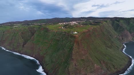 Drone-shot-of-a-lighthouse-on-a-hill-and-view-to-the-sea