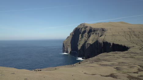 Panning-shot-of-Sudurey-island-during-blue-sky-,-view-from-Asmundarstakkur-sea-stack-on-Faroe