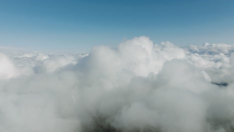 aerial flyover revealing a ocean of white clouds stretching endlessly under clear blue skies