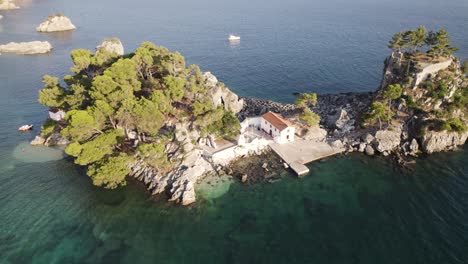 aerial arc shot around panagia island on coastline of resort town parga, greece