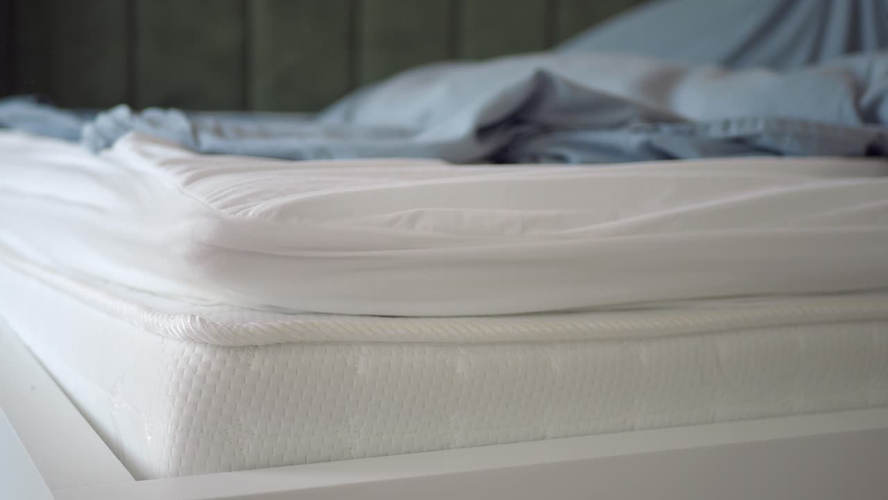 색 시트 와 밝은 회색 침대 가 있는 색 매트리스 의 클로즈업