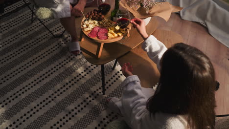 couple relaxing and enjoying wine and appetizers at home