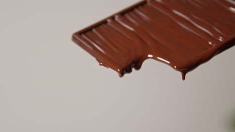 pull focus close up shot of melting chocolate bar against white background with copy space 1