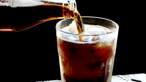 cola with ice. pouring cola with ice and bubbles in glass. soda.