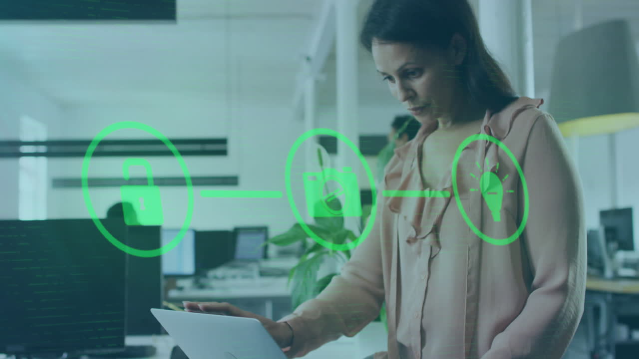 animación de una red de iconos digitales contra una mujer biracial que usa una computadora portátil en la oficina
