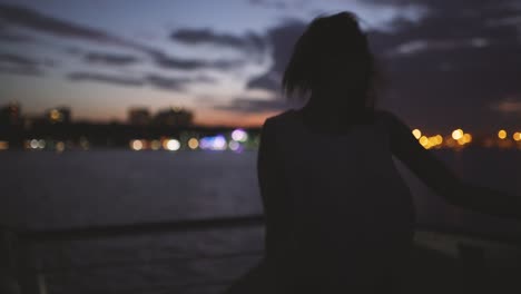 silhouette of a young happy girl feeling awesome and dance on the ship at dark night