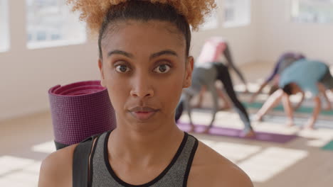 retrato de clase de yoga de una mujer feliz de raza mixta sonriendo con confianza disfrutando de un estilo de vida saludable con personas multiétnicas practicando en el fondo del gimnasio