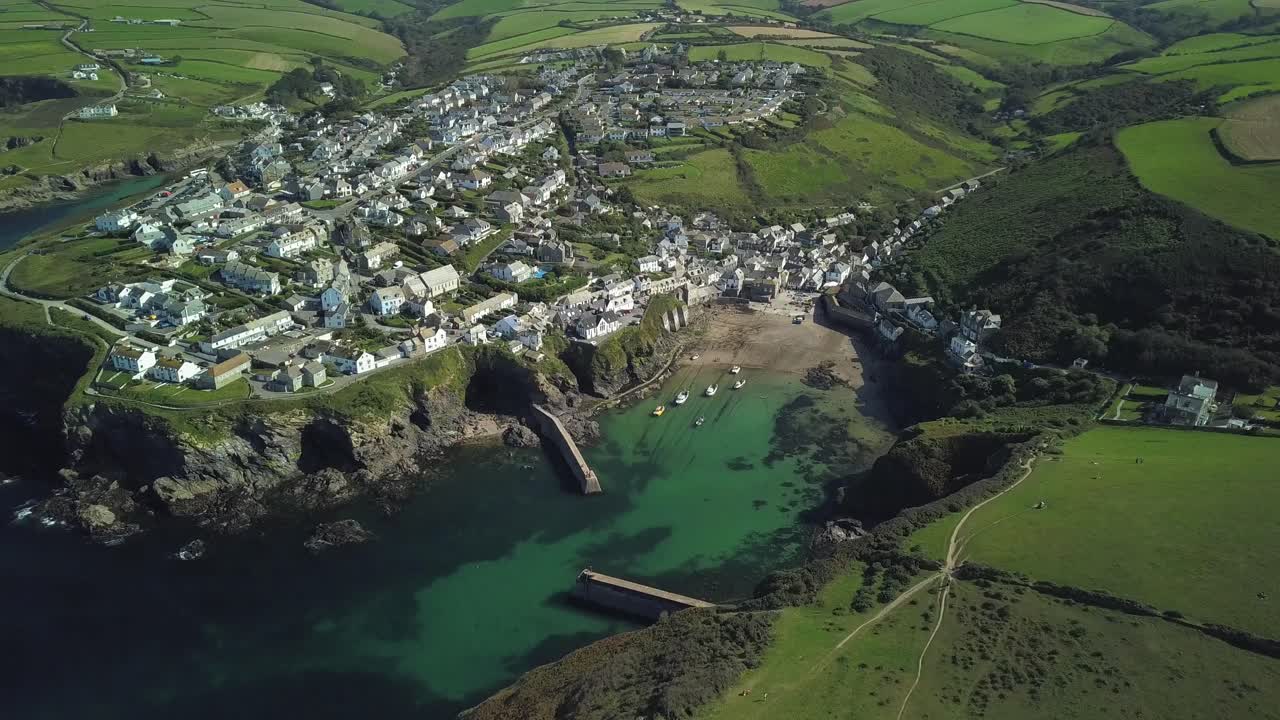 영국 콘월의 밝은 날 무성한 녹색 들판과 초원으로 둘러싸인 포트 아이작의 작은 어촌 마을