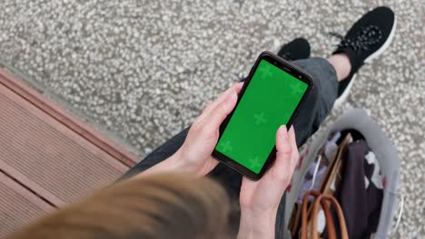 smartphone green screen mockup, top view of woman using phone.