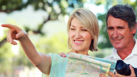 una pareja sonriente chequeando el mapa.
