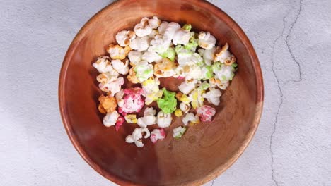 palomitas de maíz coloridas en un tazón de madera