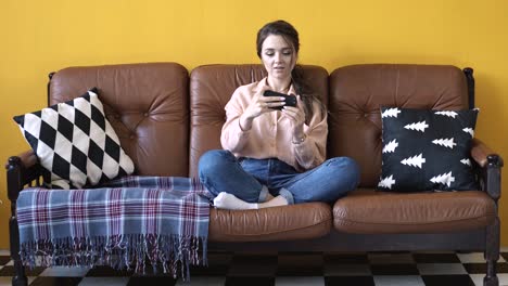 woman using a phone on a sofa