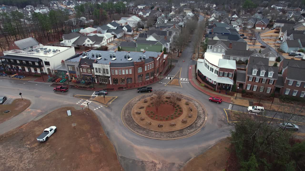 Aerial of cars driving through roundabout in front of small town shops at Moss Rock Preserve in Hoover, Alabama