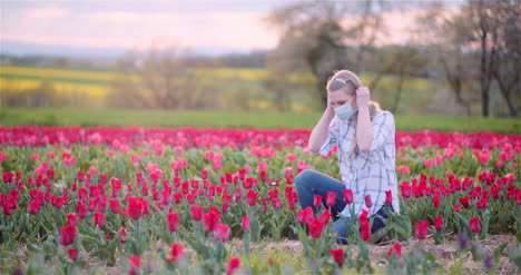 Lockdown-Shot-Of-Female-Farmer-Checking-Red-Tulips-Growing-In-Farm-During-Coronavirus-Outbreak