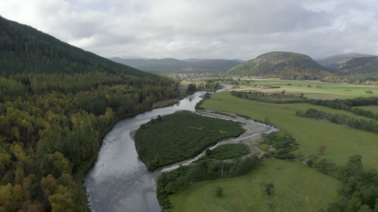 Aerial view of the River Dee near the Scottish town of Ballater in the Cairngorms National Park, Aberdeenshire. Flying forward over fields and the river.