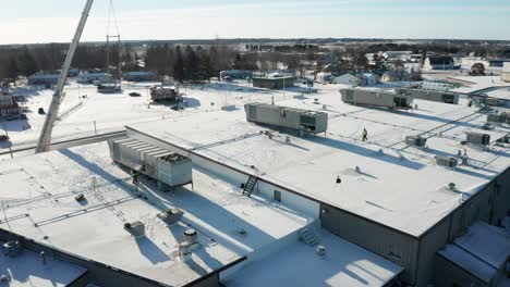 aerial, industrial building roof top with new hvac units installed during winter