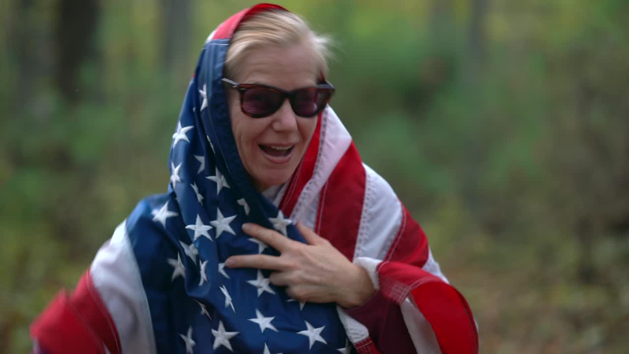Woman wrapped in American flag making peace sign