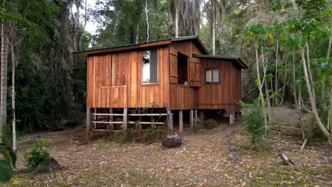 Stetiger-Drohnenschuss,-Der-Auf-Eine-Hölzerne-Waldhütte-Im-Regenwald-Von-Misiones,-Argentinien,-Zufliegt