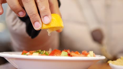 preparando una ensalada con limón