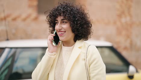 young woman smiling confident talking on the smartphone at street