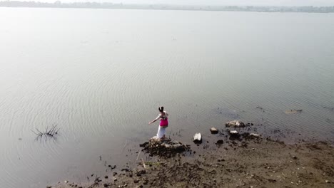 A-bharatnatyam-dancer-displaying-a-classical-bharatnatyam-pose-in-the-nature-of-Vadatalav-lake,-Pavagadh