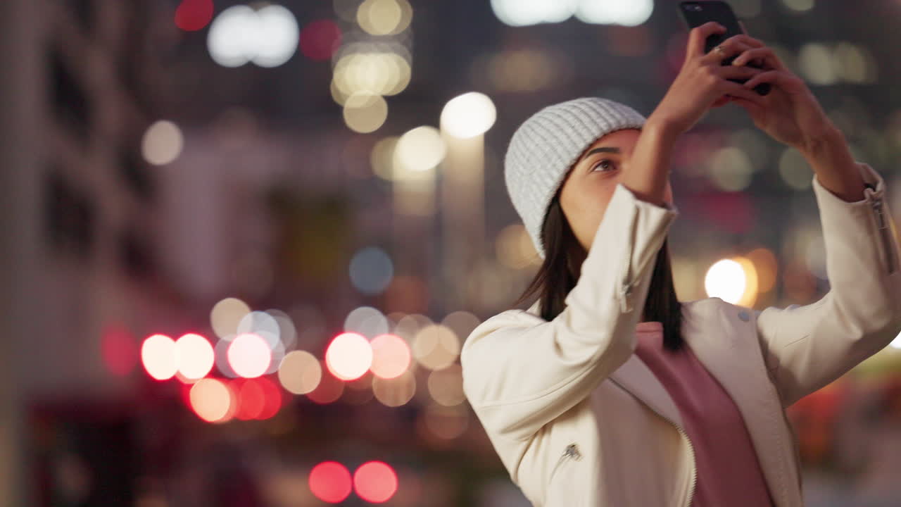 휴대폰을 들고 있는 트렌디한 나이트라이프 블로거