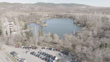 drone shot of small lake and parking next to it