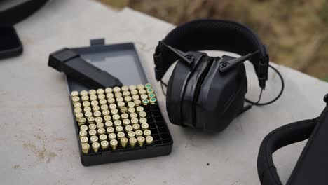 9mm-ammunition-pack-and-earmuff-on-Olesko-shooting-range-table,-Czechia