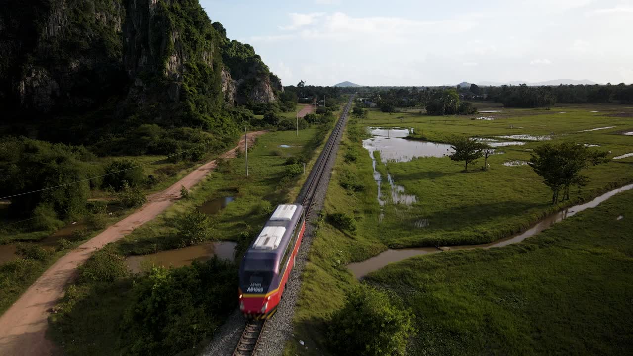 tren de pasajeros que viaja a través de la pintoresca campiña de camboya