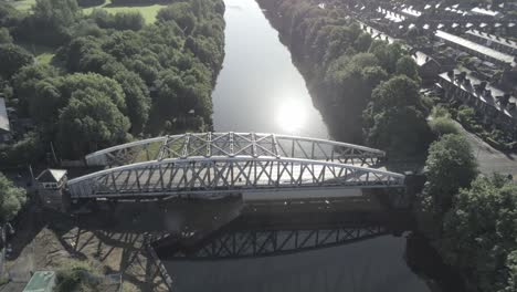 aerial view scenic old vintage steel archway traffic footbridge rising tilt down above manchester ship canal crossing