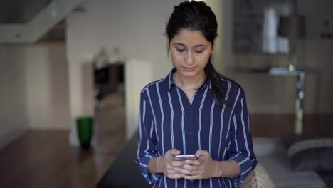 Focused-serious-female-phone-user-texting-message