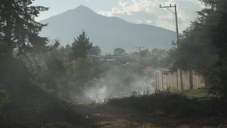 smoke from a small fire on a dusty rural road in mexico