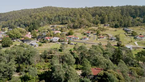 la ciudad tasmaniana de derby vista por avión no tripulado con casas de vacaciones y el desierto en un día soleado, tasmania, australia