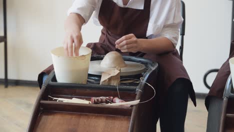 master class on modeling of clay on a potter wheel in the pottery workshop