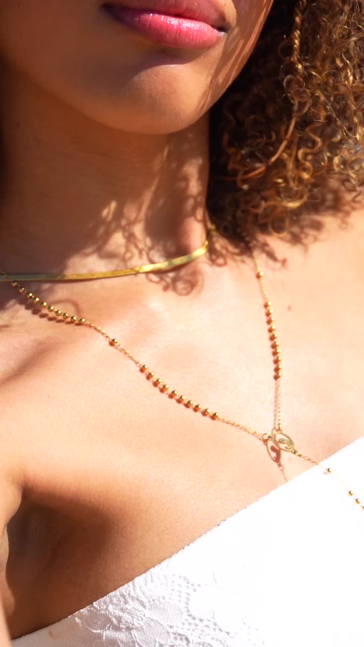 Woman with sunglasses and curly hair on the beach