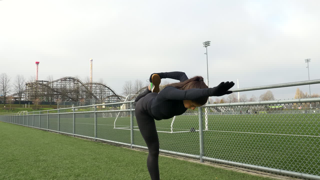 운동 후 다리를 스트레칭하는 검은 운동복을 입은 소녀, 슬로우 모션