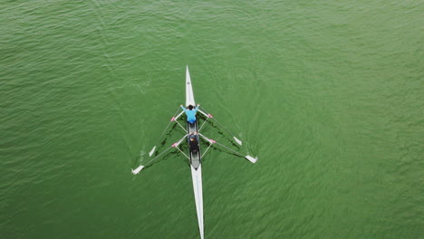 two people rowing on a canoe over a large asian river