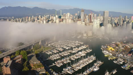 aerial flying away from the scenic downtown vancouver skyline on a misty morning