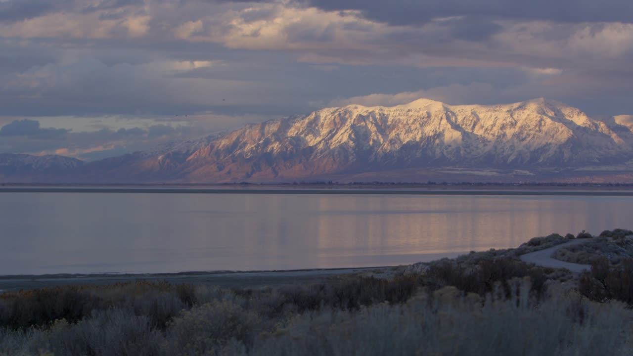 Bellezza epica delle montagne dello Utah che si estendono vicino a un lago al tramonto, in slow motion cinematografico.
