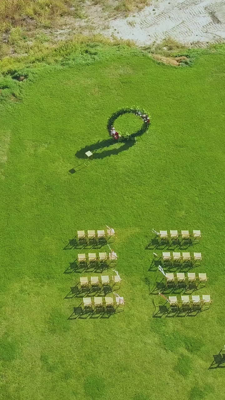 elegant round wedding venue and empty chairs on fresh green meadow grass on sunny day upper view