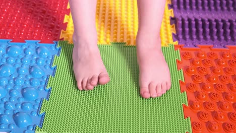 the child does exercises on the orthopedic mat, legs close-up