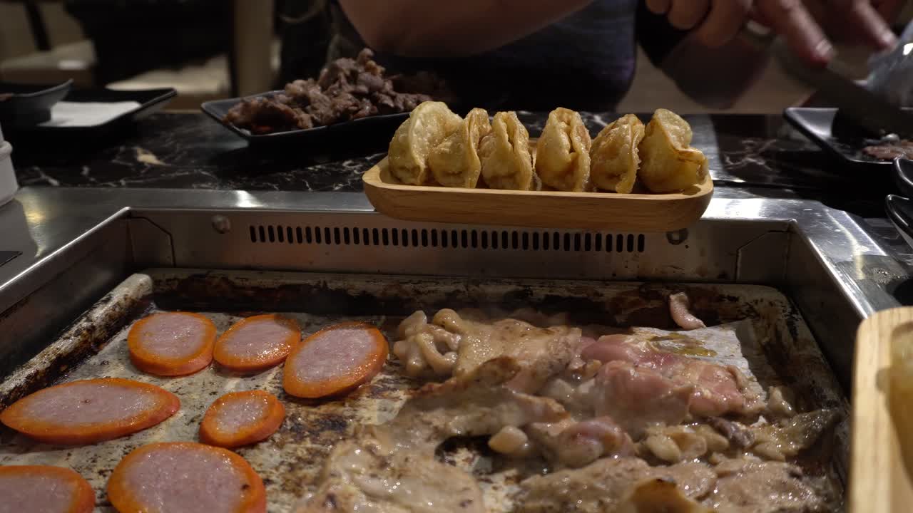 se puede ver la carne que se cocina en una parrilla coreana barbacoa