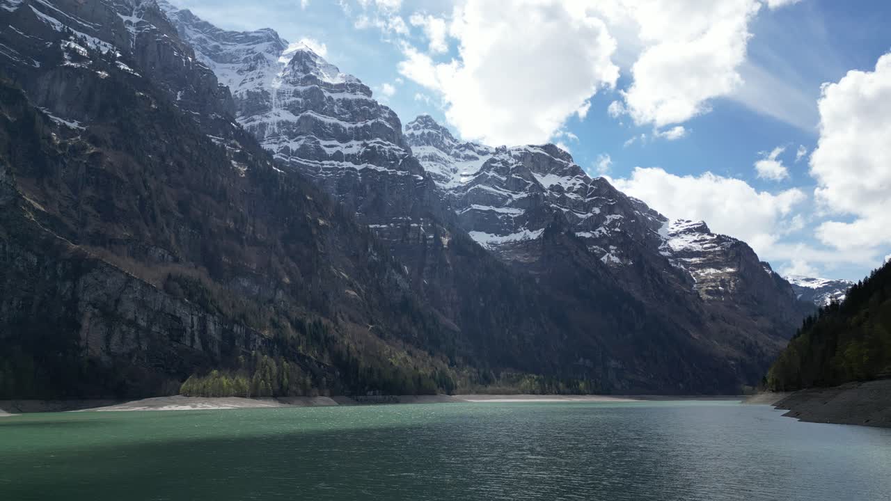 lago azul rodeado de montañas cubiertas de nieve y un cielo nublado