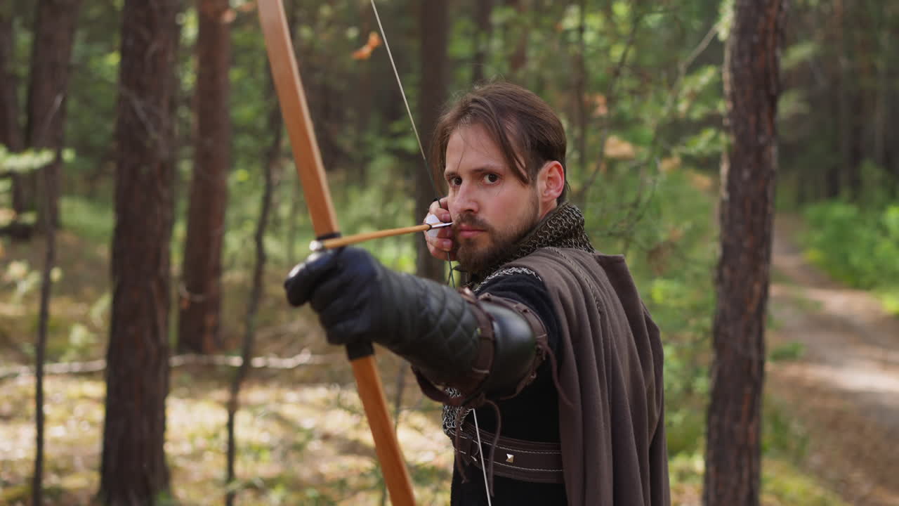 caballero en la cadena de correo tira de la cuerda del arco