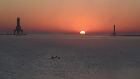 Un-Hermoso-Amanecer-En-El-Lago-Michigan-Con-Un-Faro-Y-Un-Rompeolas