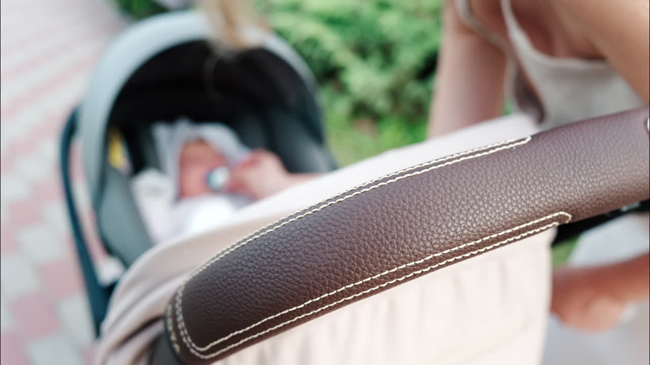 Close up of a mother placing a pacifier into a baby's mouth while seated in a stroller