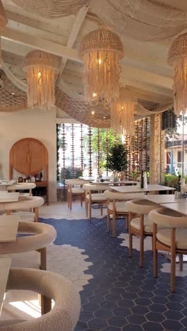 soft lighting highlights a well-set breakfast table in a stylish dining area adorned with marine-themed decor. the elegant furnishings invite a serene morning atmosphere perfect for gatherings.