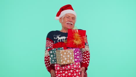 grandfather old man in christmas santa sweater holding many gift boxes new year presents shopping