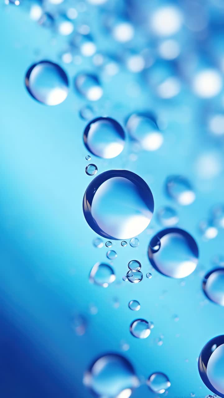 Primo piano, ripresa dall'alto di gocce d'acqua su una superficie blu, per un effetto rinfrescante e rilassante