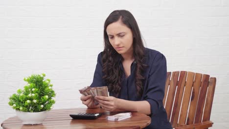 chica india confundida contando dinero